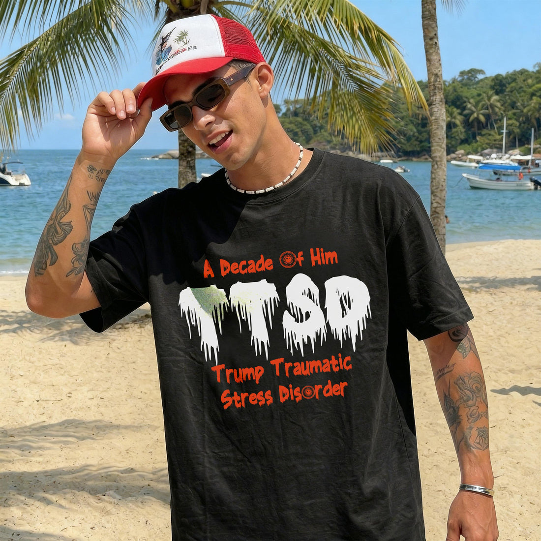 Man wearing a black t-shirt with &amp;quot;Trump Traumatic Stress Disorder&amp;quot; printed on it, by the beach.
