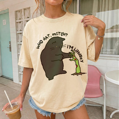 Black cat graphic on beige t-shirt with text &amp;quot;WHO DAT, MITCH?&amp;quot; and &amp;quot;I&amp;