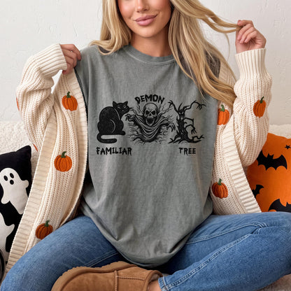 T-shirt with demon, skull, cat, and tree design, with pumpkin-decorated cardigan.