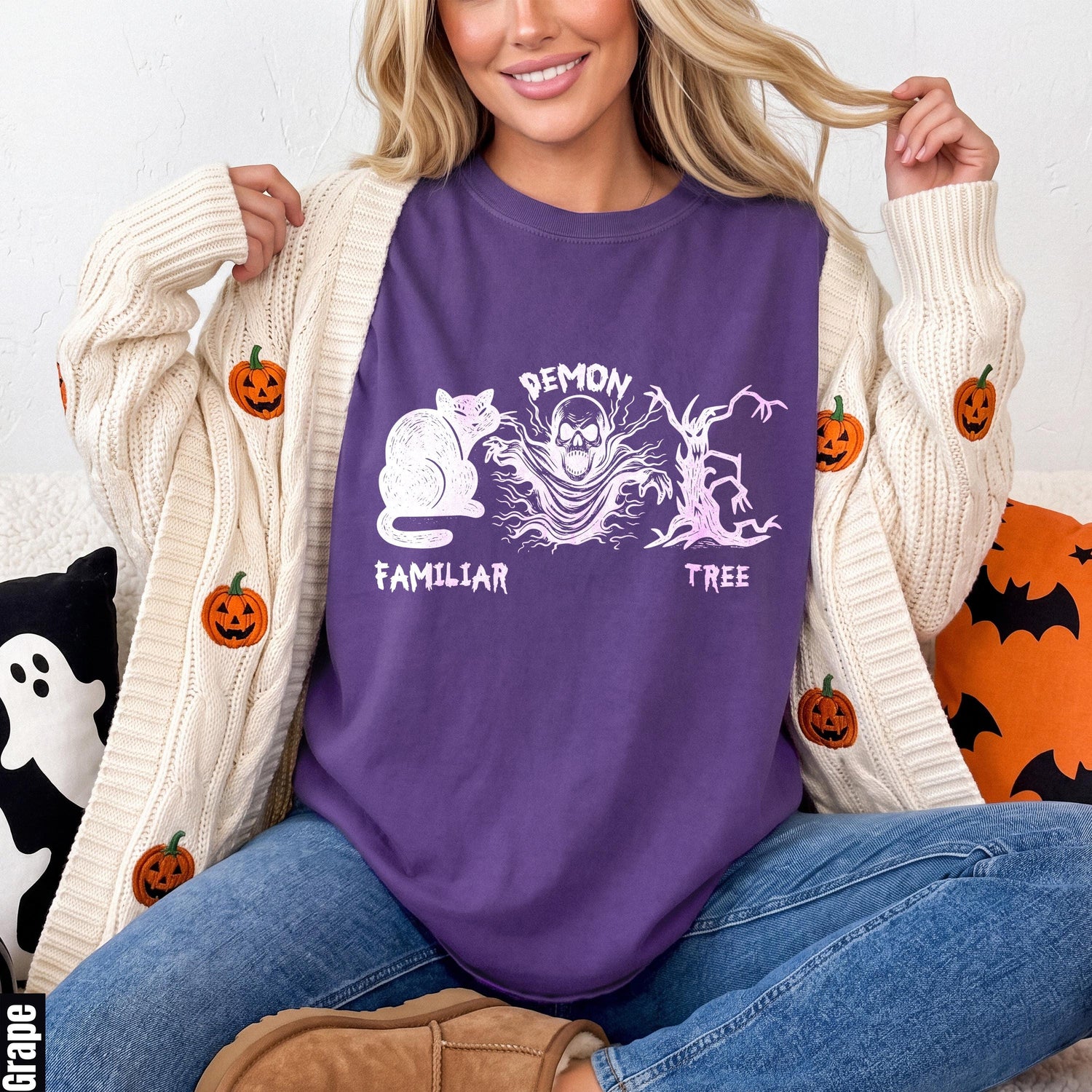 Purple t-shirt with white cat, skull, and demon tree graphics.