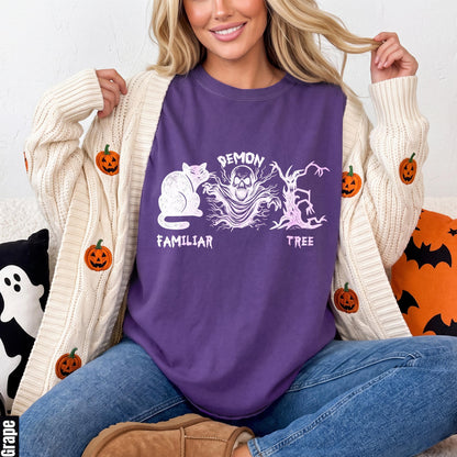 Purple t-shirt with white cat, skull, and demon tree graphics.