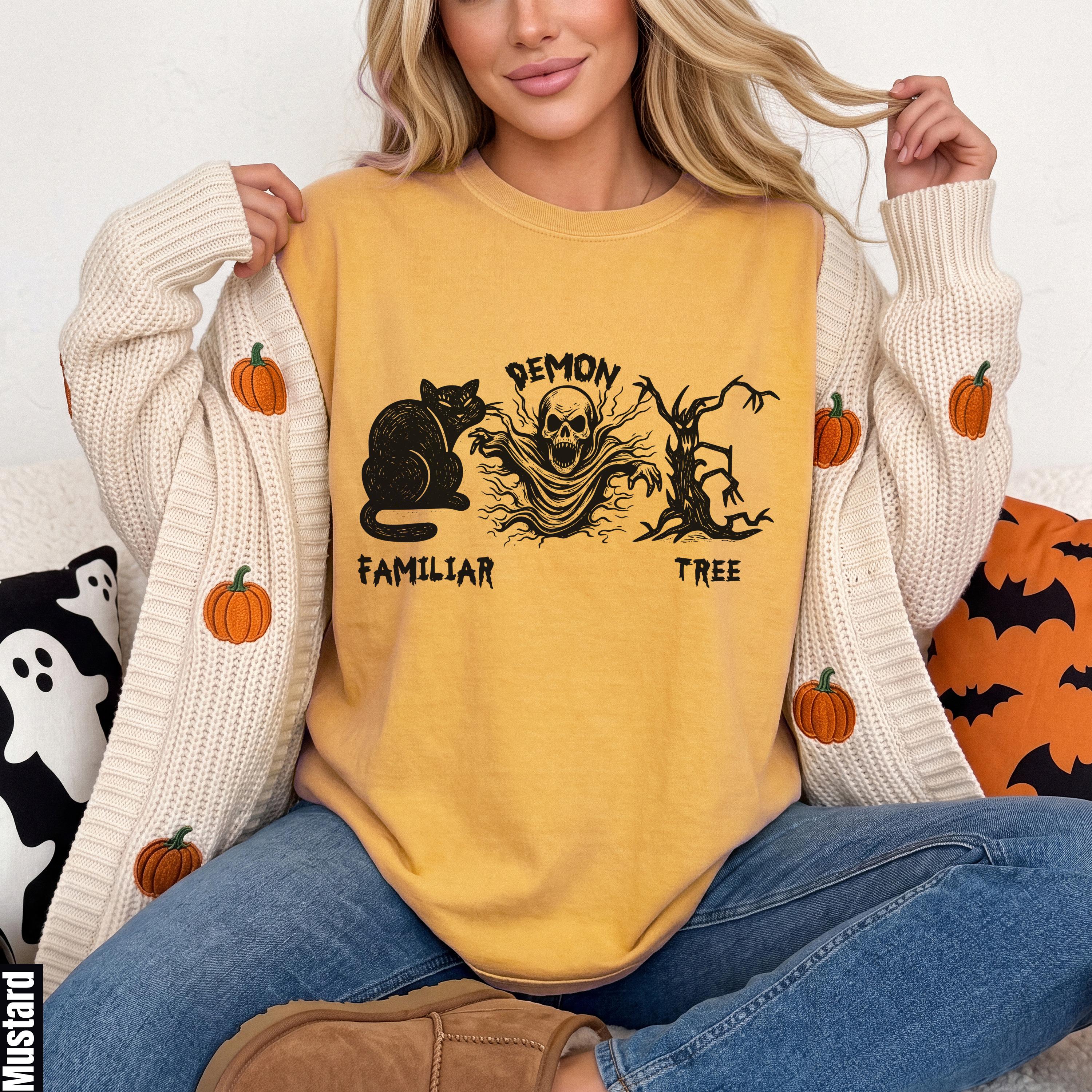 Yellow t-shirt with black Halloween graphic: cat, demon skull, and tree.