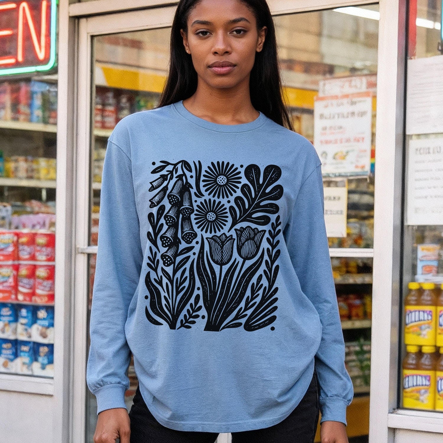 Blue long-sleeve shirt with black graphic of flowers and leaves.