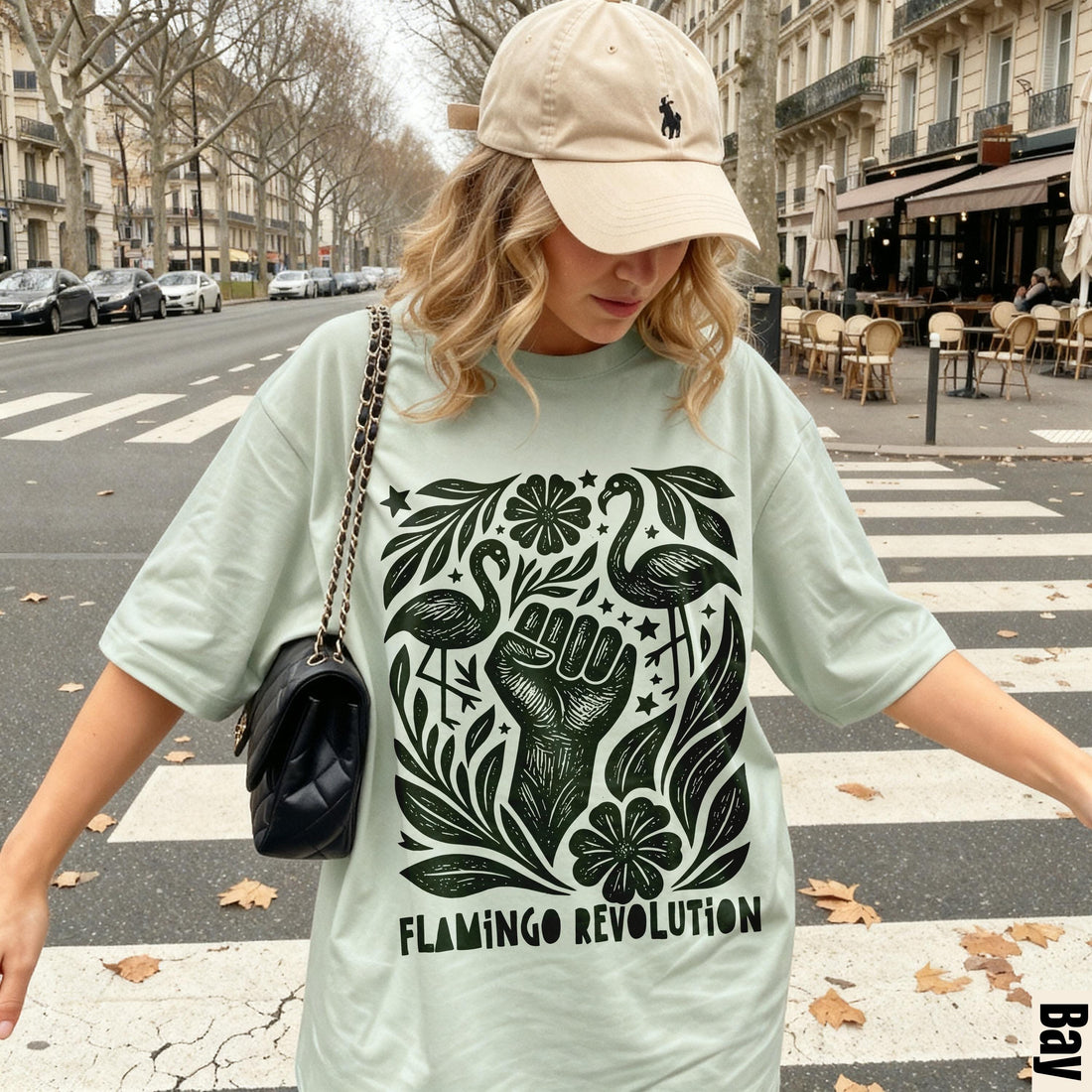 Light green t-shirt with black &amp;quot;Flamingo Revolution&amp;quot; graphic, featuring a raised fist, flamingos, and foliage.
