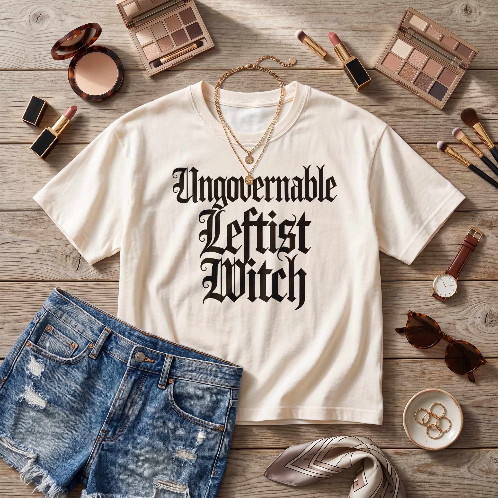 Cream t-shirt with gothic text &amp;quot;Ungovernable Leftist Witch&amp;quot;, denim shorts, makeup and accessories.