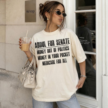 Cream t-shirt with black text: &amp;quot;ABDUL FOR SENATE MONEY OUT OF POLITICS MONEY IN YOUR POCKET MEDICARE FOR ALL&amp;quot;.