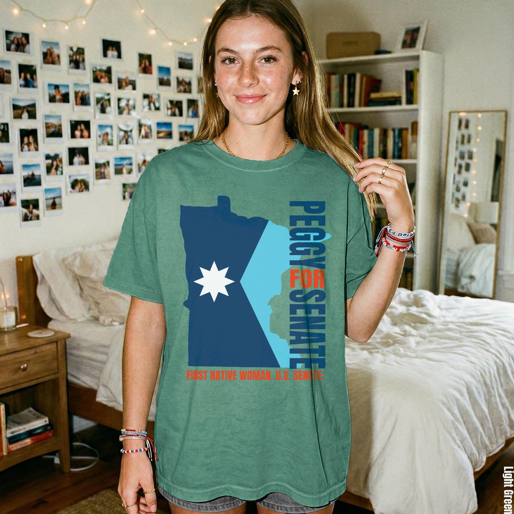 Green t-shirt with a Minnesota map graphic and text &amp;quot;Peggy for Senate First Native Woman U.S. Senate&amp;quot;.