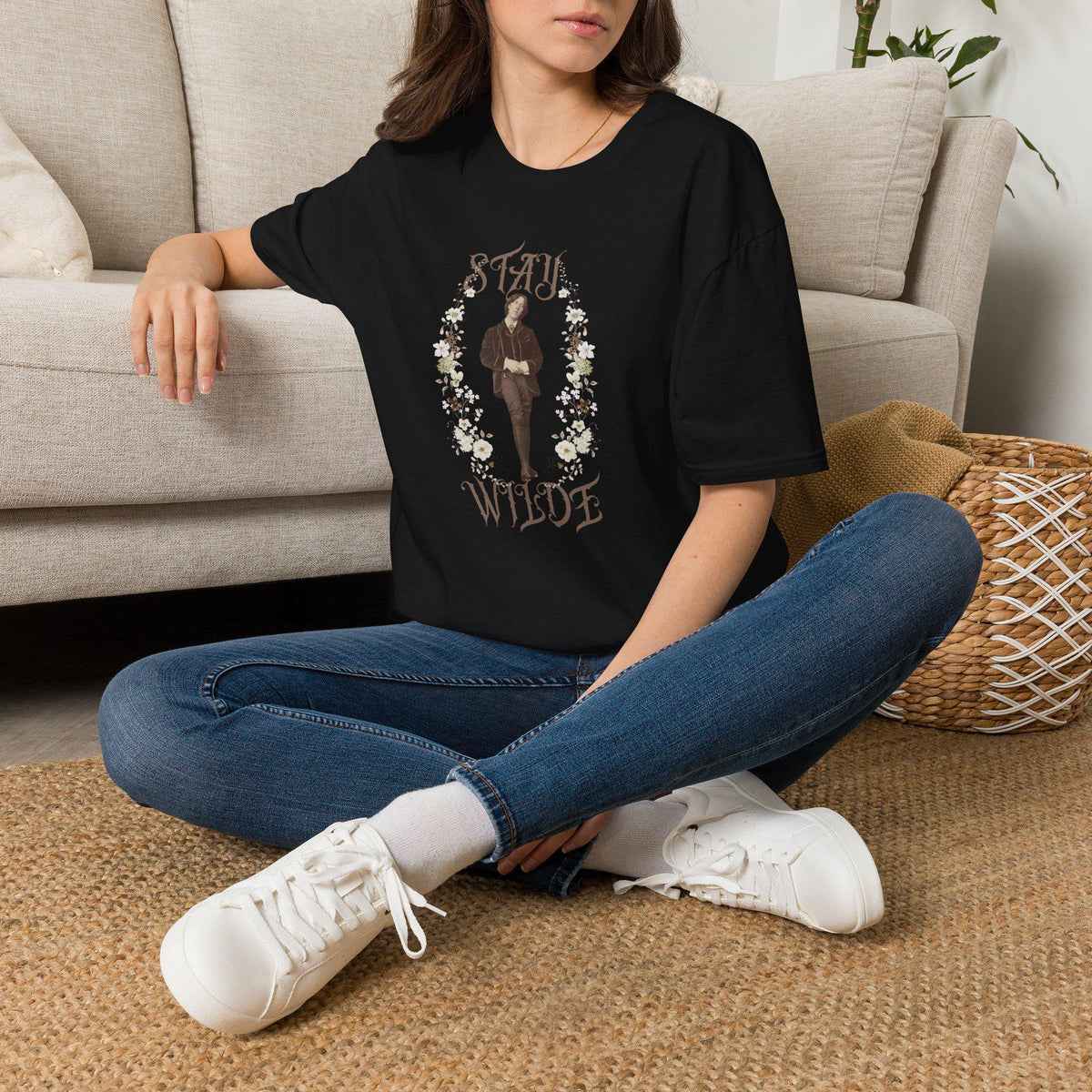 May include: A black short-sleeved t-shirt featuring a central graphic of a person in a brown suit surrounded by a floral wreath. The text &amp;quot;STAY&amp;quot; appears above the figure and &amp;quot;WILDE&amp;quot; appears below in a decorative, serif font style.