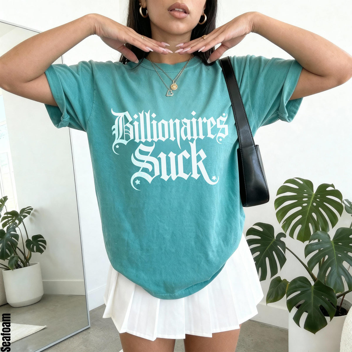 Teal t-shirt with white &amp;quot;Billionaires Suck&amp;quot; graphic and a white pleated skirt.