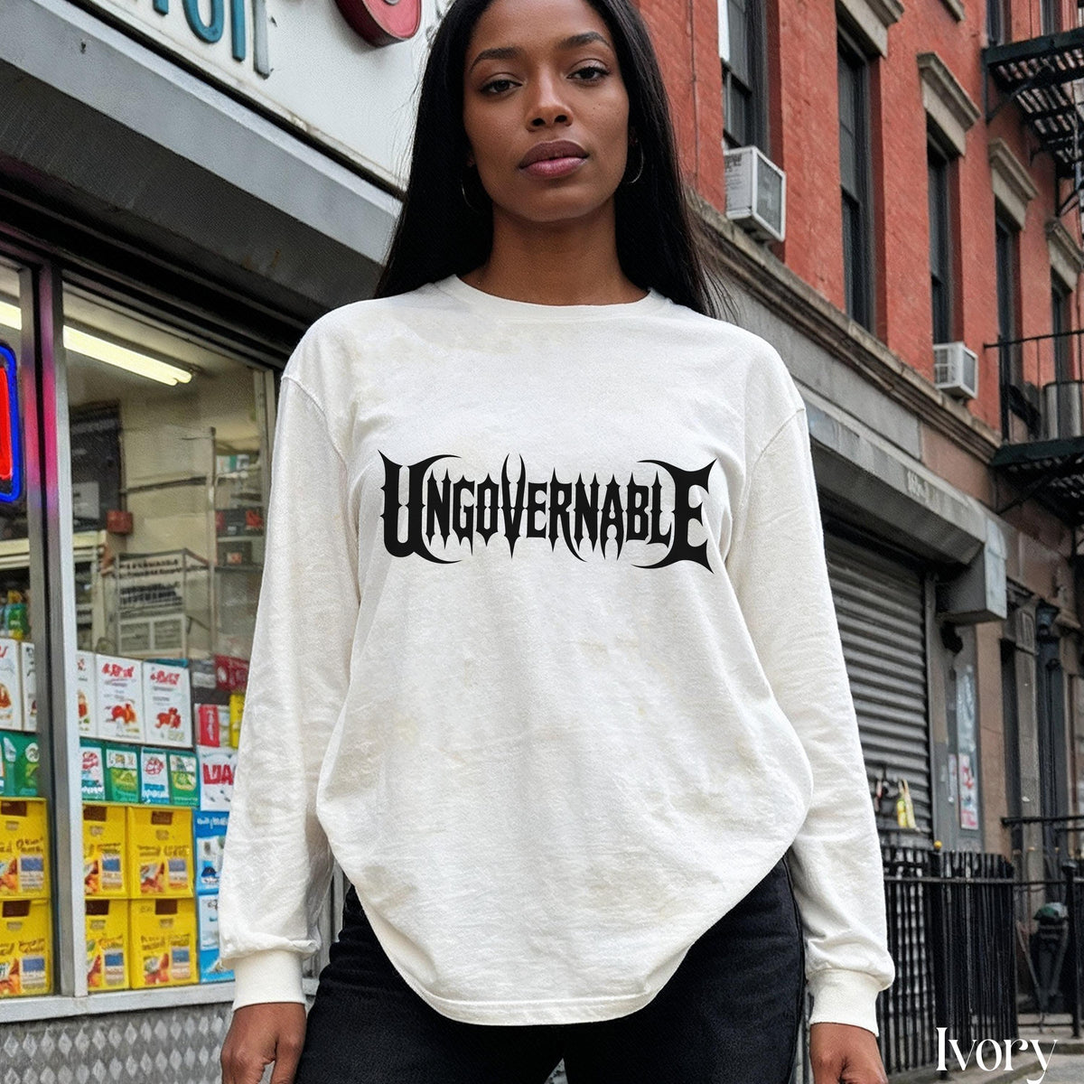 Woman wearing an ivory long-sleeve shirt with &amp;quot;UNGOVERNABLE&amp;quot; graphic text.