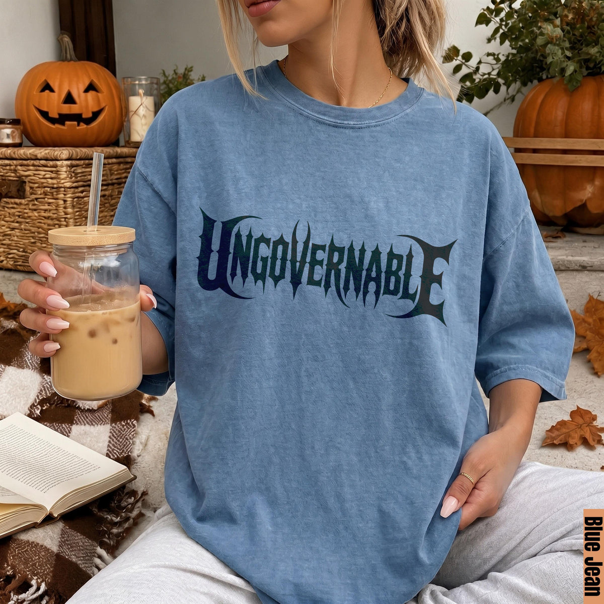 Blue Jean t-shirt with &amp;quot;Ungovernable&amp;quot; text, holding iced coffee, Halloween decor.