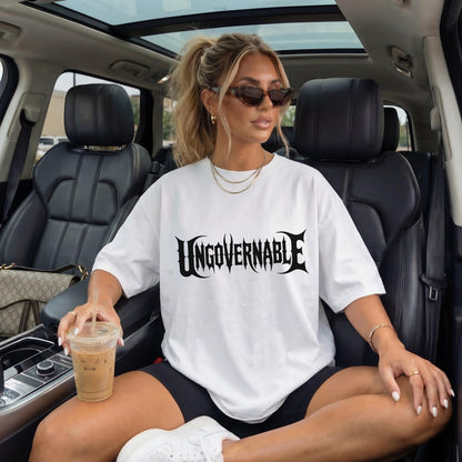 Woman in white t-shirt with &amp;quot;UNGVVERNABLE&amp;quot; graphic sitting in car.