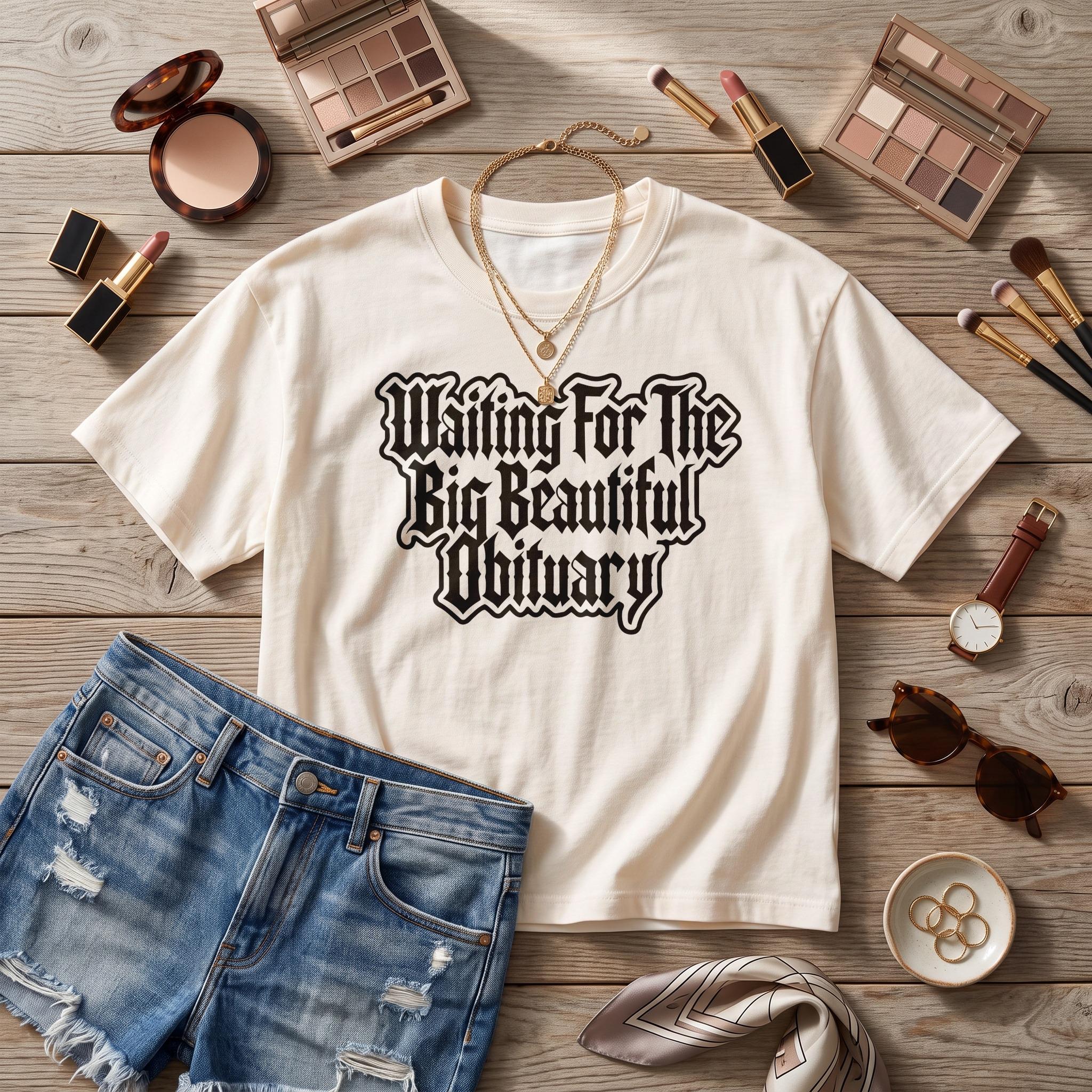 Cream t-shirt with black gothic text &amp;quot;Waiting For The Big Beautiful Obituary&amp;quot;.
