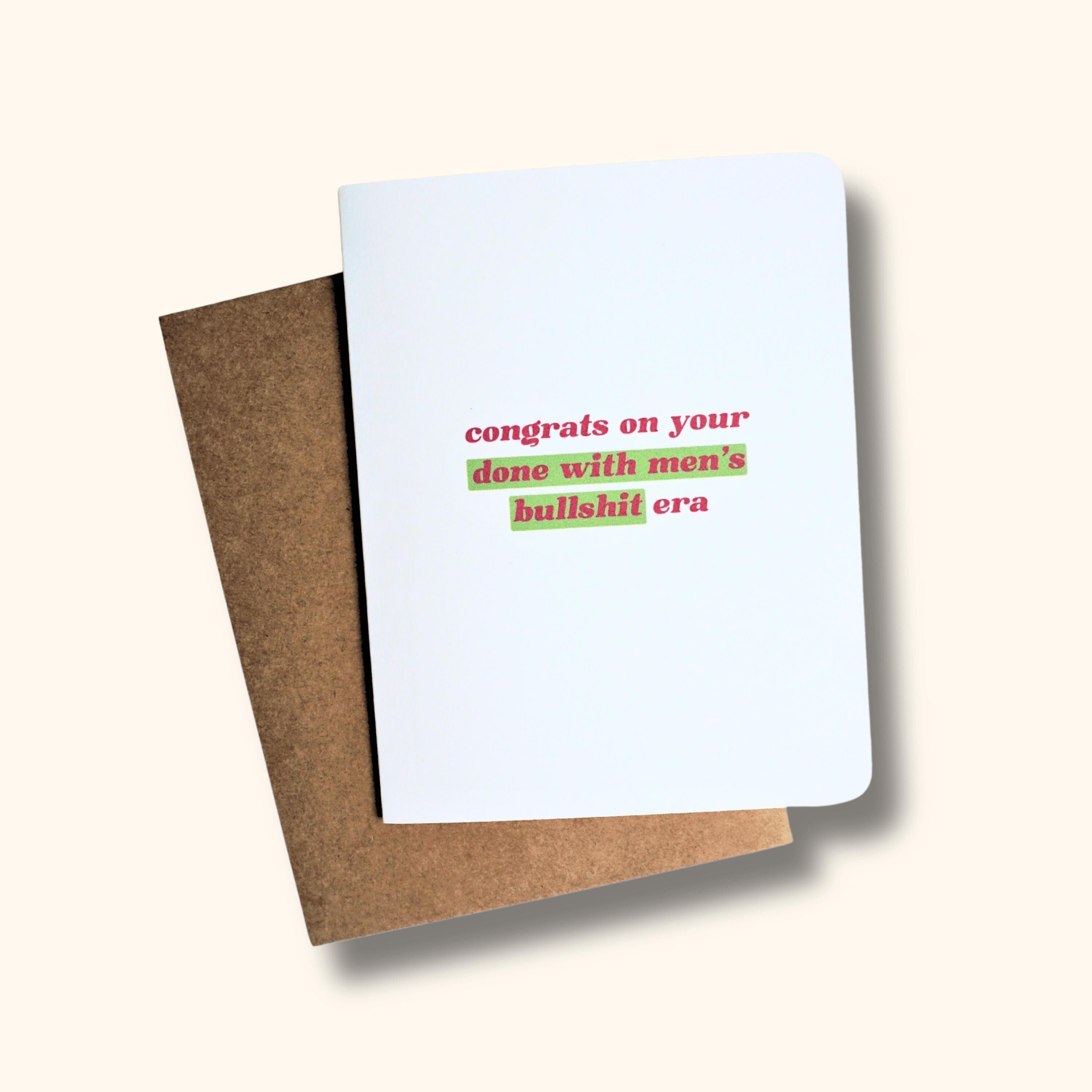 White greeting card with rounded corners on top of brown kraft envelope. Card says "congrats on your done with men&