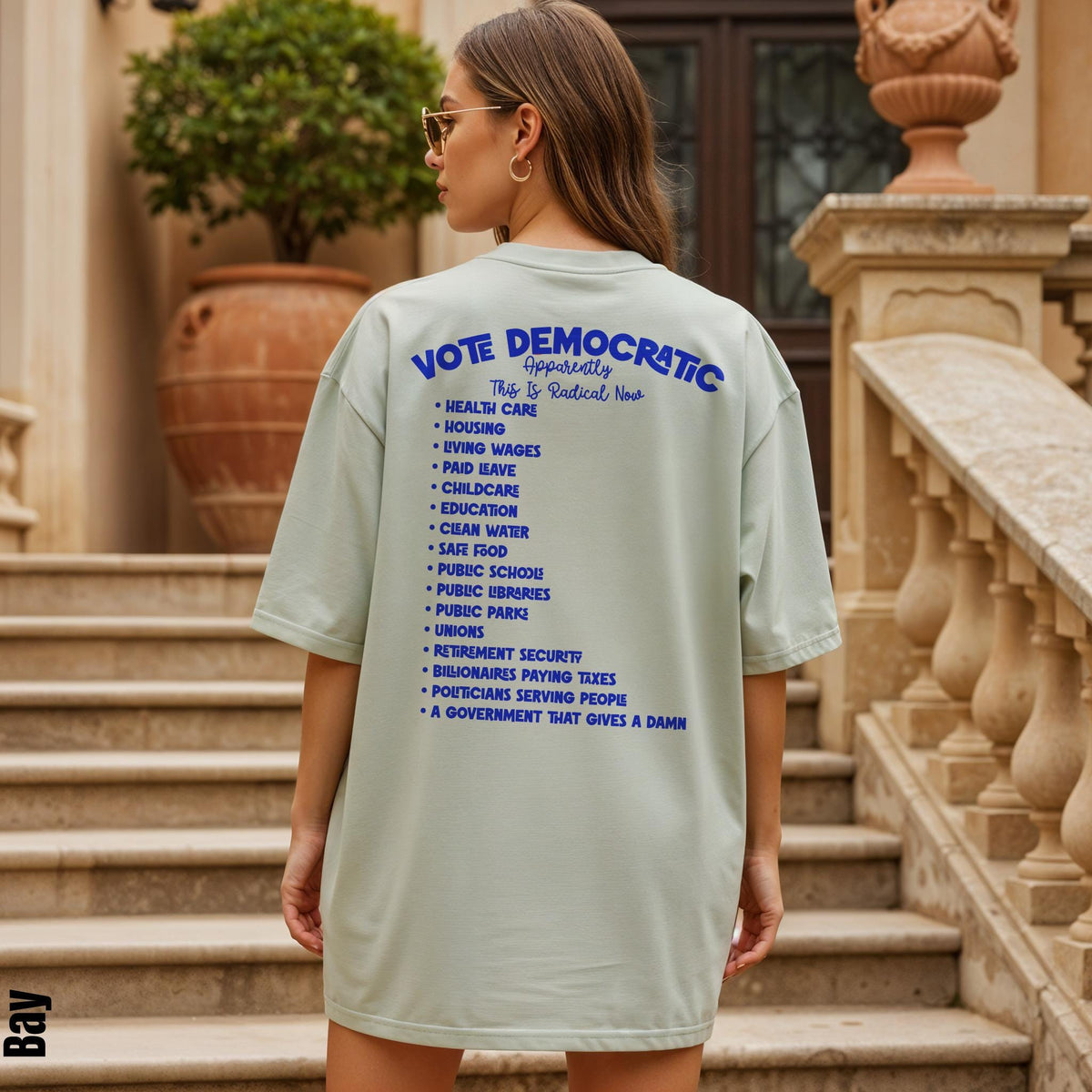 Light green t-shirt with blue text: &amp;quot;Vote Democratic Apparently This Is Radical Now&amp;quot; and a list of policy points.