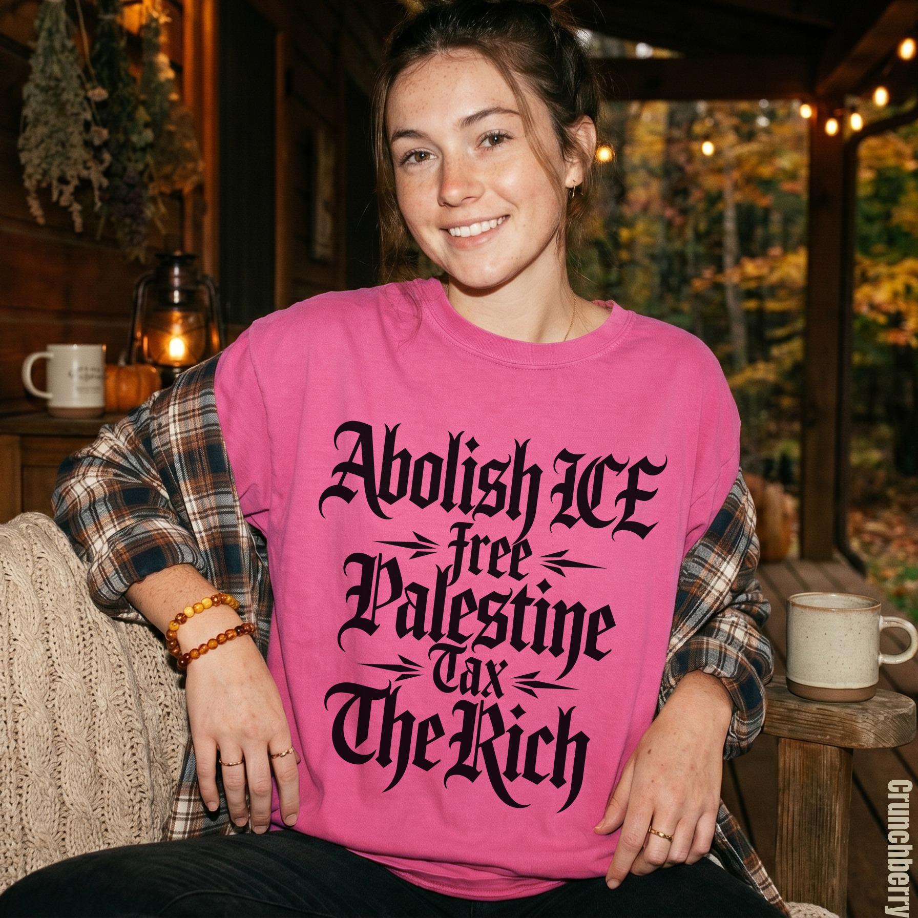 Pink t-shirt with black text reading &amp;quot;Abolish ICE&amp;quot;, &amp;quot;free Palestine&amp;quot;, &amp;quot;Tax The Rich&amp;quot;.