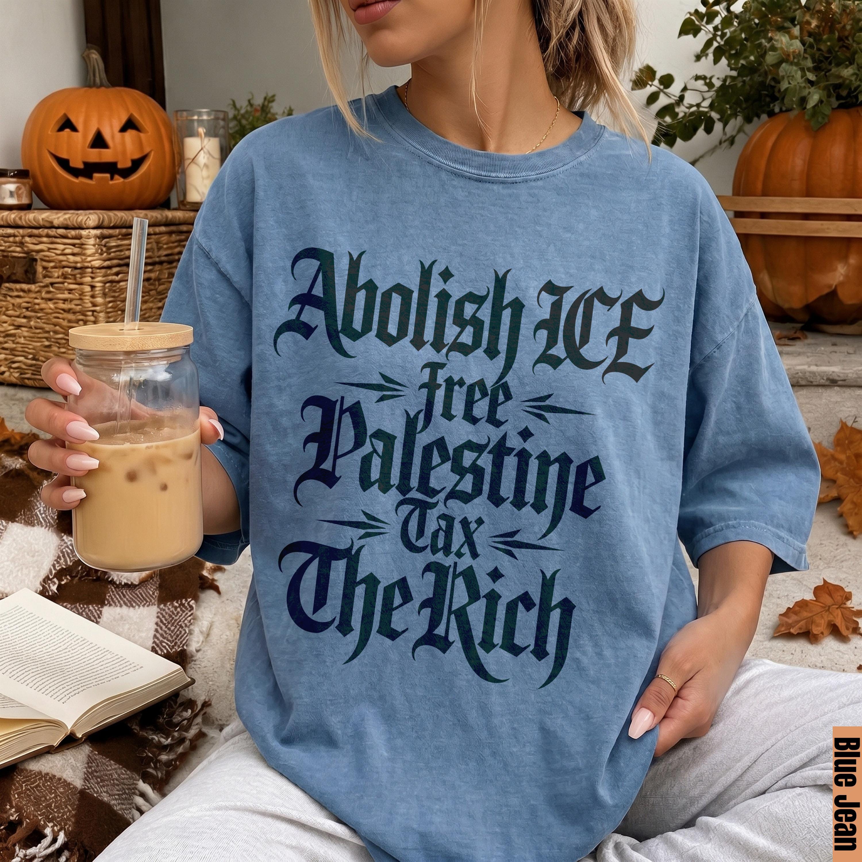 Blue t-shirt with &amp;quot;Abolish ICE free Palestine Tax The Rich&amp;quot; text in gothic font.