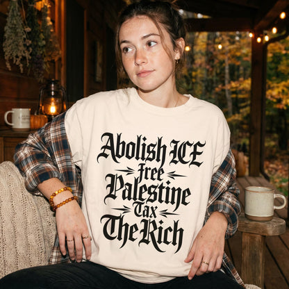 Woman wearing cream shirt with text &amp;quot;Abolish ICE free Palestine Tax The Rich&amp;quot;.