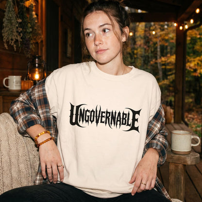 Woman wearing a cream t-shirt with black &amp;quot;Ungovernable&amp;quot; graphic text.