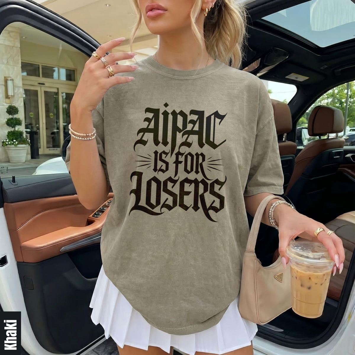 Woman in khaki t-shirt with &amp;quot;Aipac is for Losers&amp;quot; text, holding iced coffee.