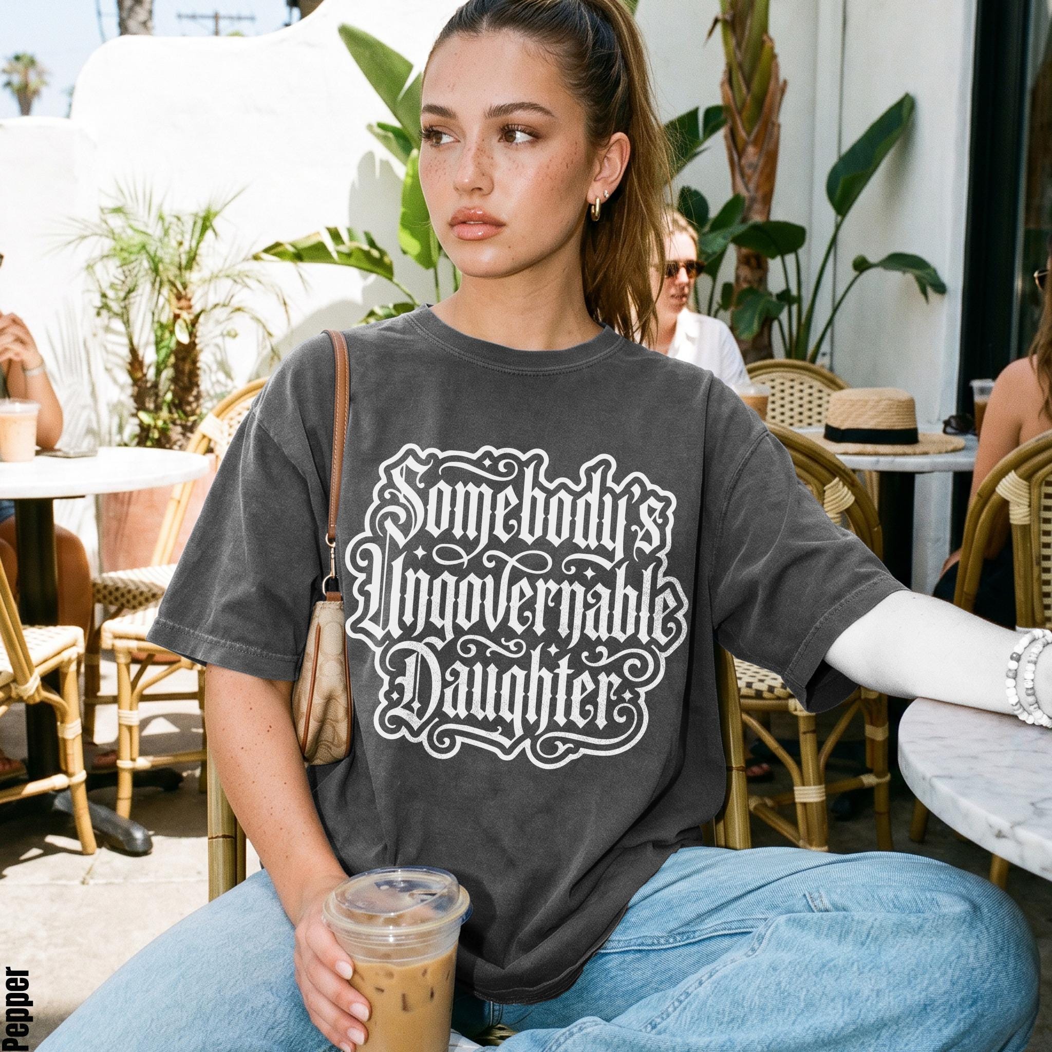 Woman wearing dark t-shirt with white &amp;quot;Somebody&amp;