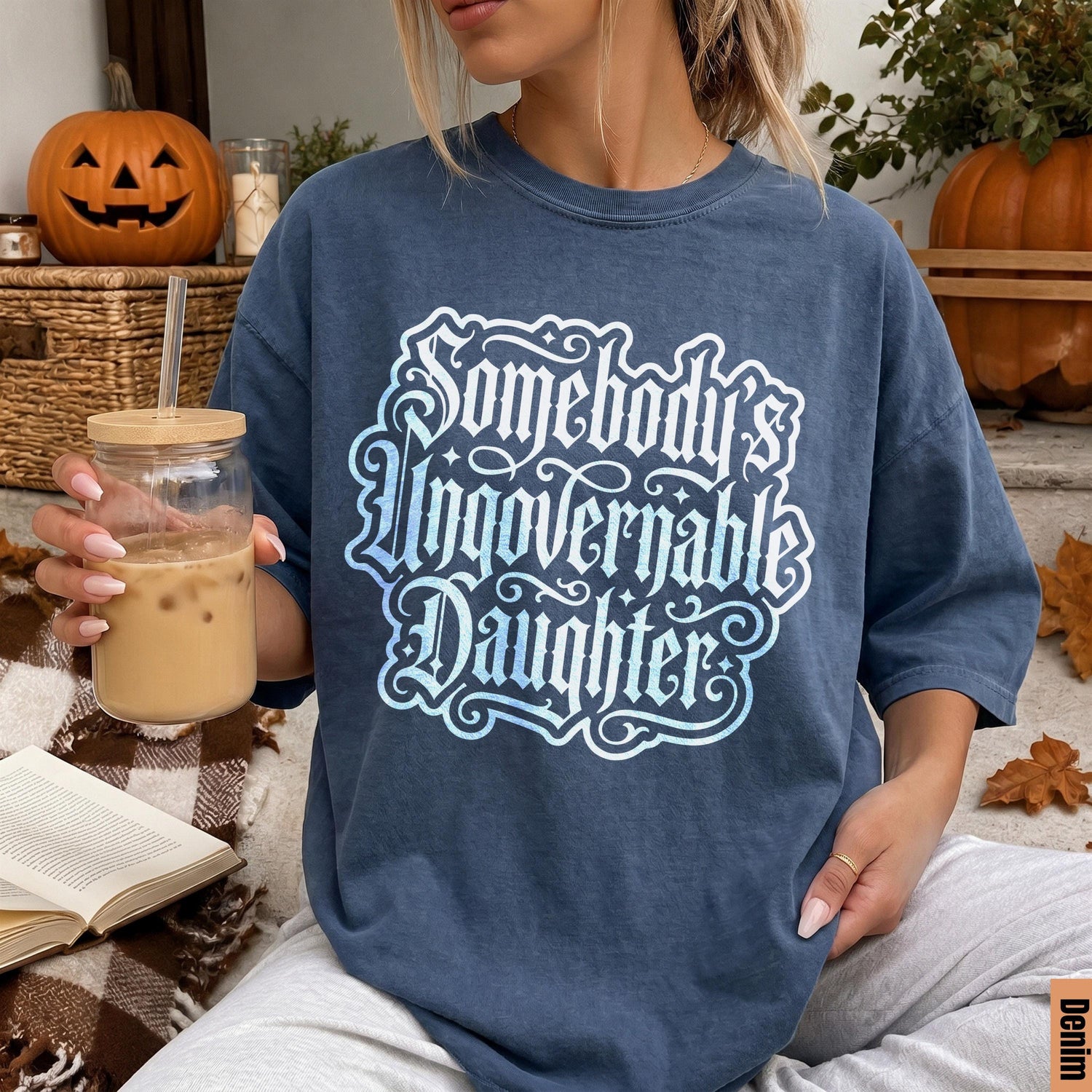 Blue t-shirt with white text &amp;quot;Somebody Ungovernable Daughter&amp;quot; and Halloween decor.