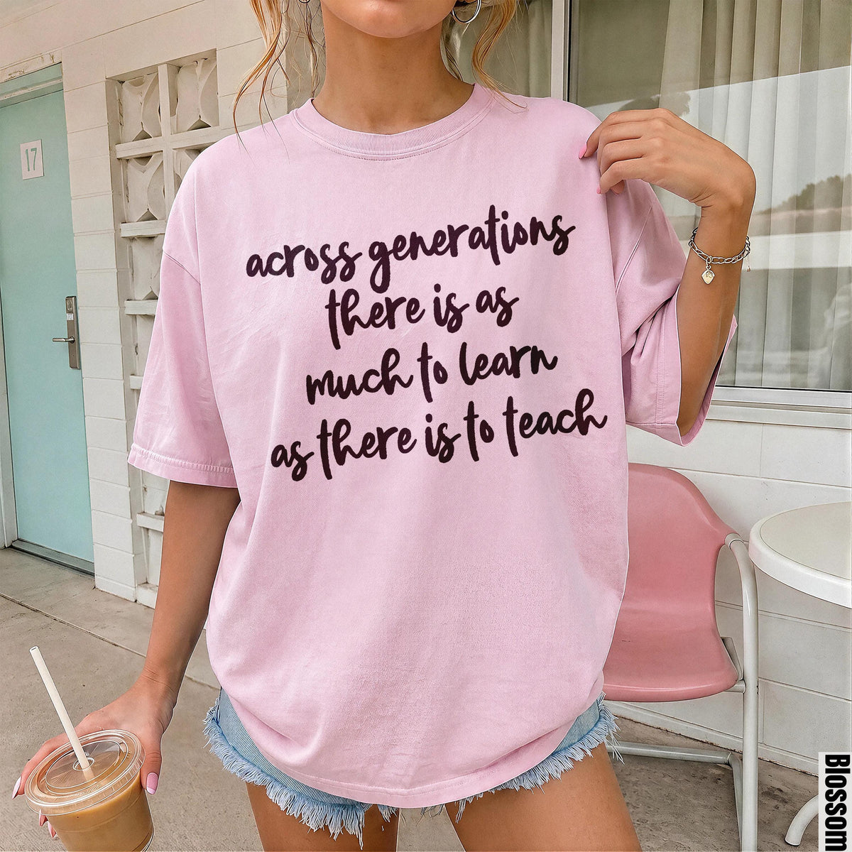 Pink t-shirt with dark text reading &amp;quot;across generations there is as much to learn as there is to teach&amp;quot;.
