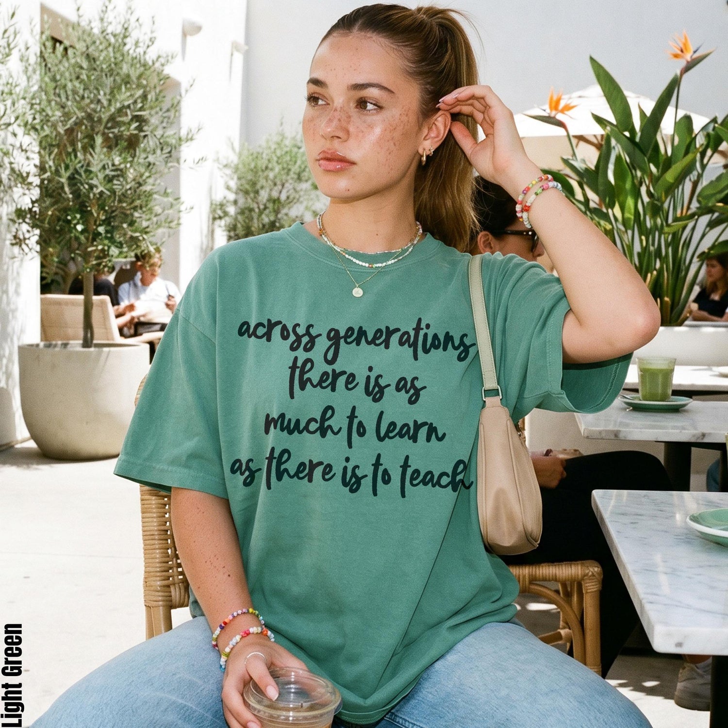 Green t-shirt with text &amp;quot;across generations there is as much to learn as there is to teach&amp;quot;.