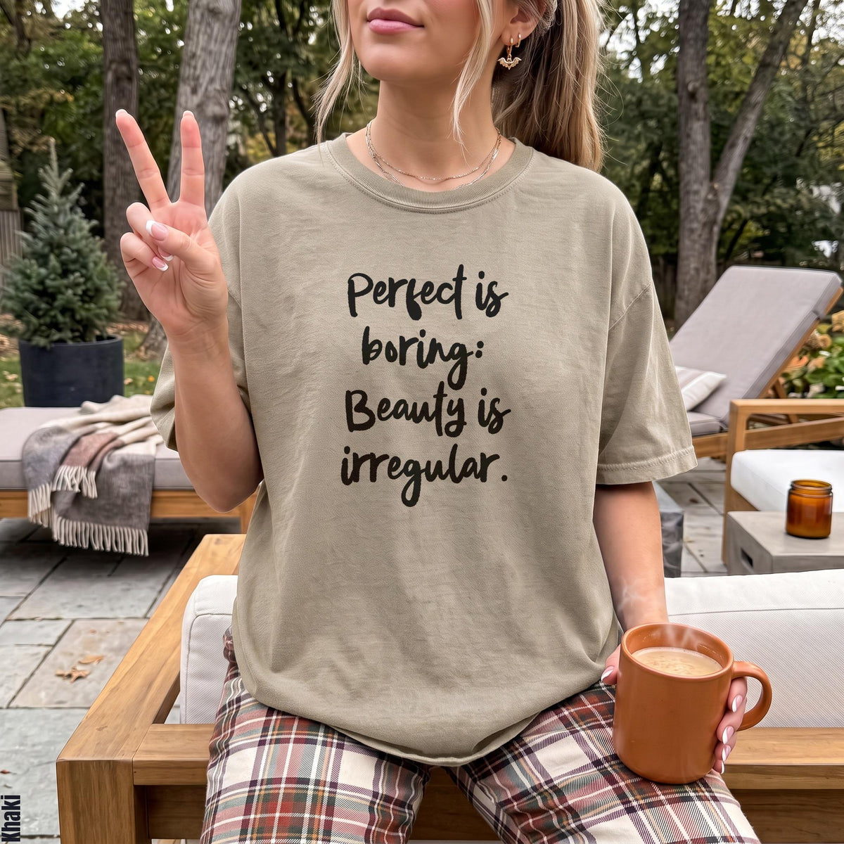 T-shirt with &amp;quot;Perfect is boring: Beauty is irregular&amp;quot; text, held mug, peace sign.