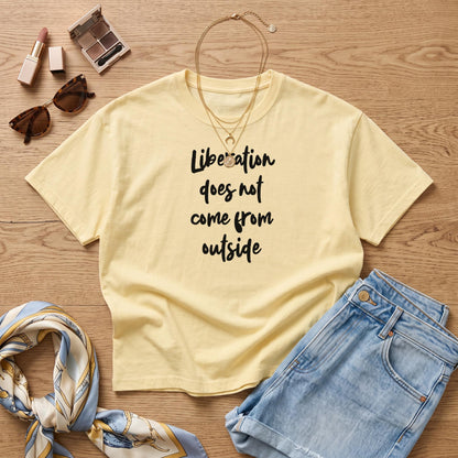 Pale yellow t-shirt with black text &amp;quot;Liberation does not come from outside&amp;quot;.