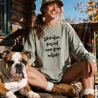 Woman wearing a light green long-sleeve shirt with text &amp;quot;Liberation does not come from outside&amp;quot; and a bulldog.