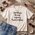 Cream t-shirt with text "Empathy is the most radical of human emotions," denim shorts, and accessories.