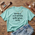 Teal t-shirt with black text "None of us can be liberated if other groups are not."
