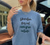 Blue t-shirt with "Liberation does not come from outside" text, held by a person in a car.