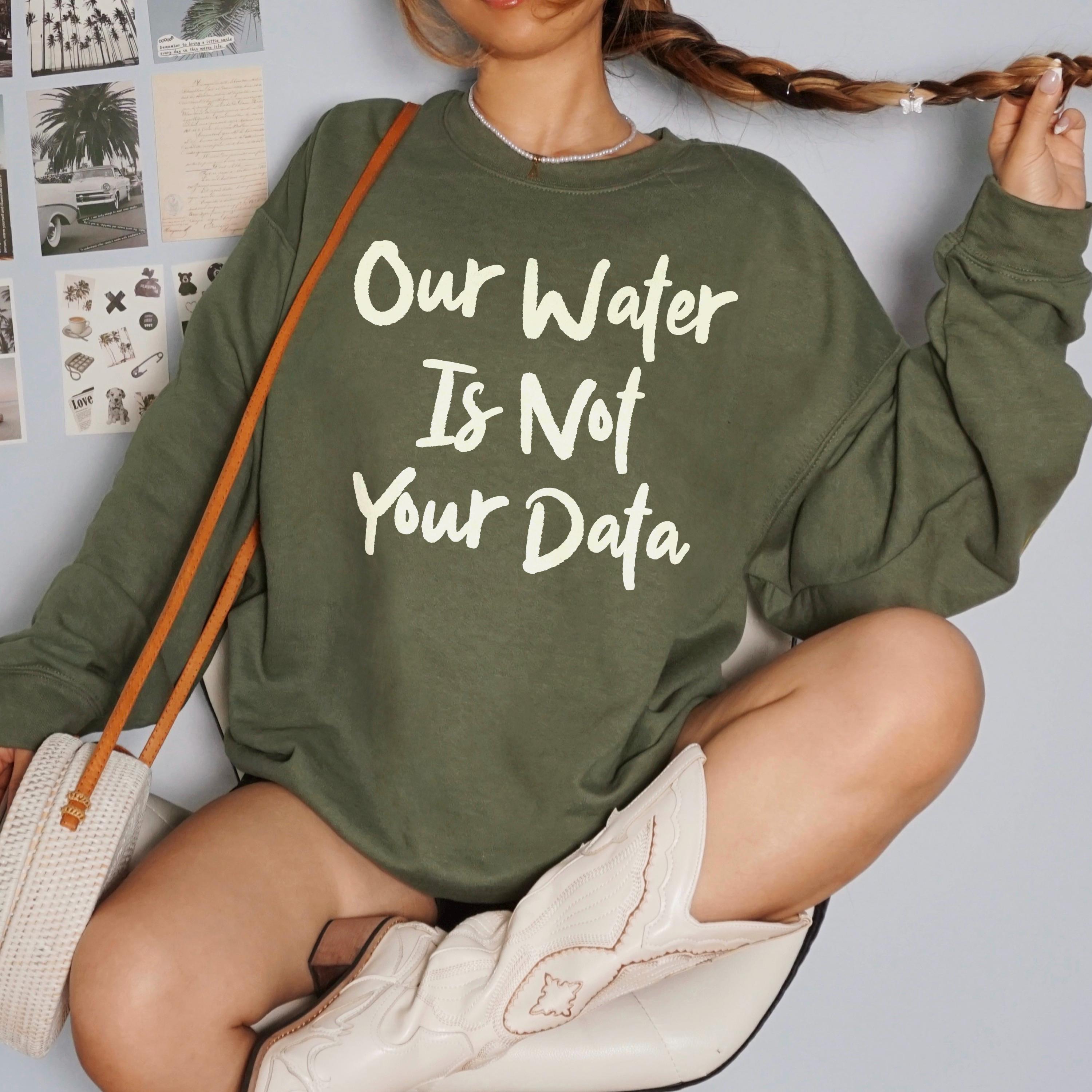 Green sweatshirt with white text &amp;quot;Our Water Is Not Your Data&amp;quot;.