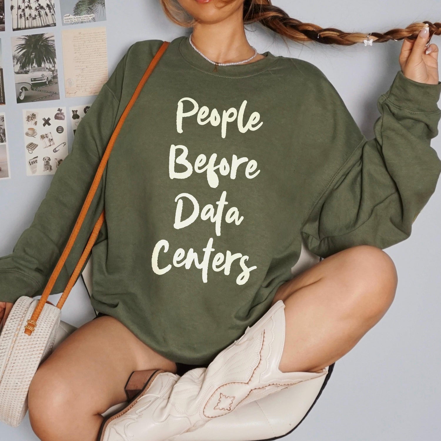 Green sweatshirt with white text &amp;quot;People Before Data Centers&amp;quot;.