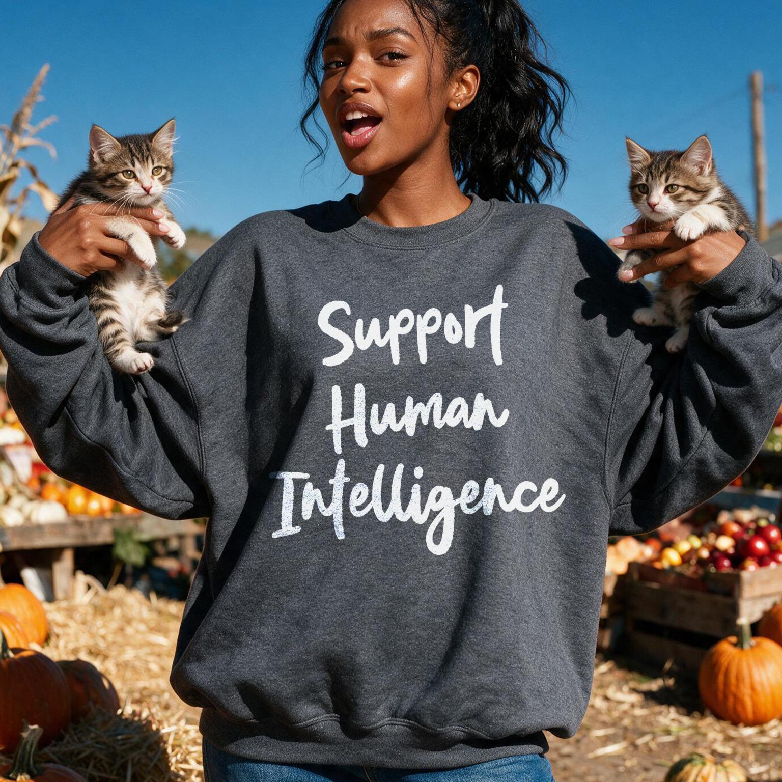 Woman holding kittens, wearing dark grey sweatshirt with &amp;quot;Support Human Intelligence&amp;quot; text.