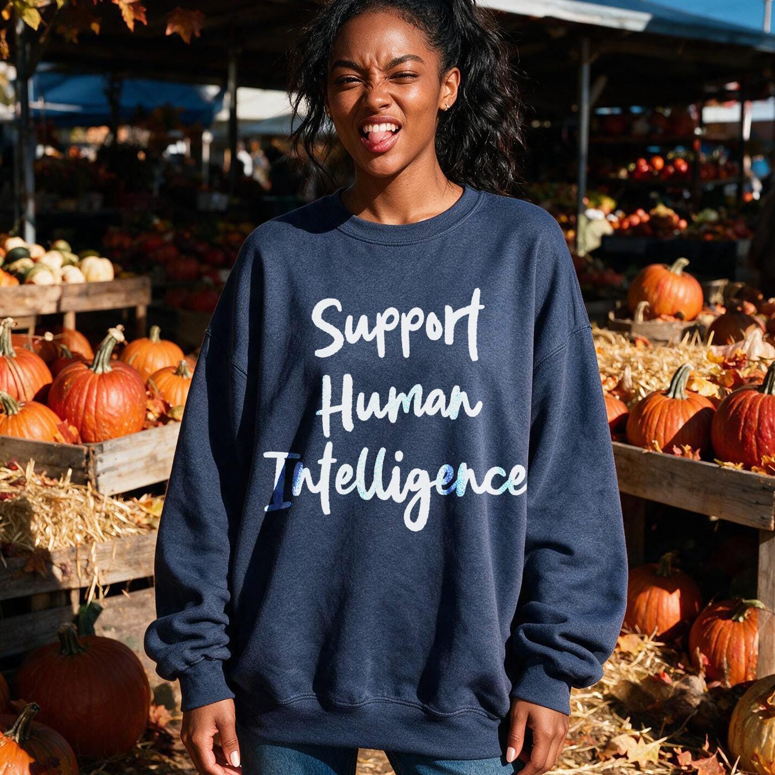 Dark blue sweatshirt with white text &amp;quot;Support Human Intelligence&amp;quot; on a backdrop of pumpkins.