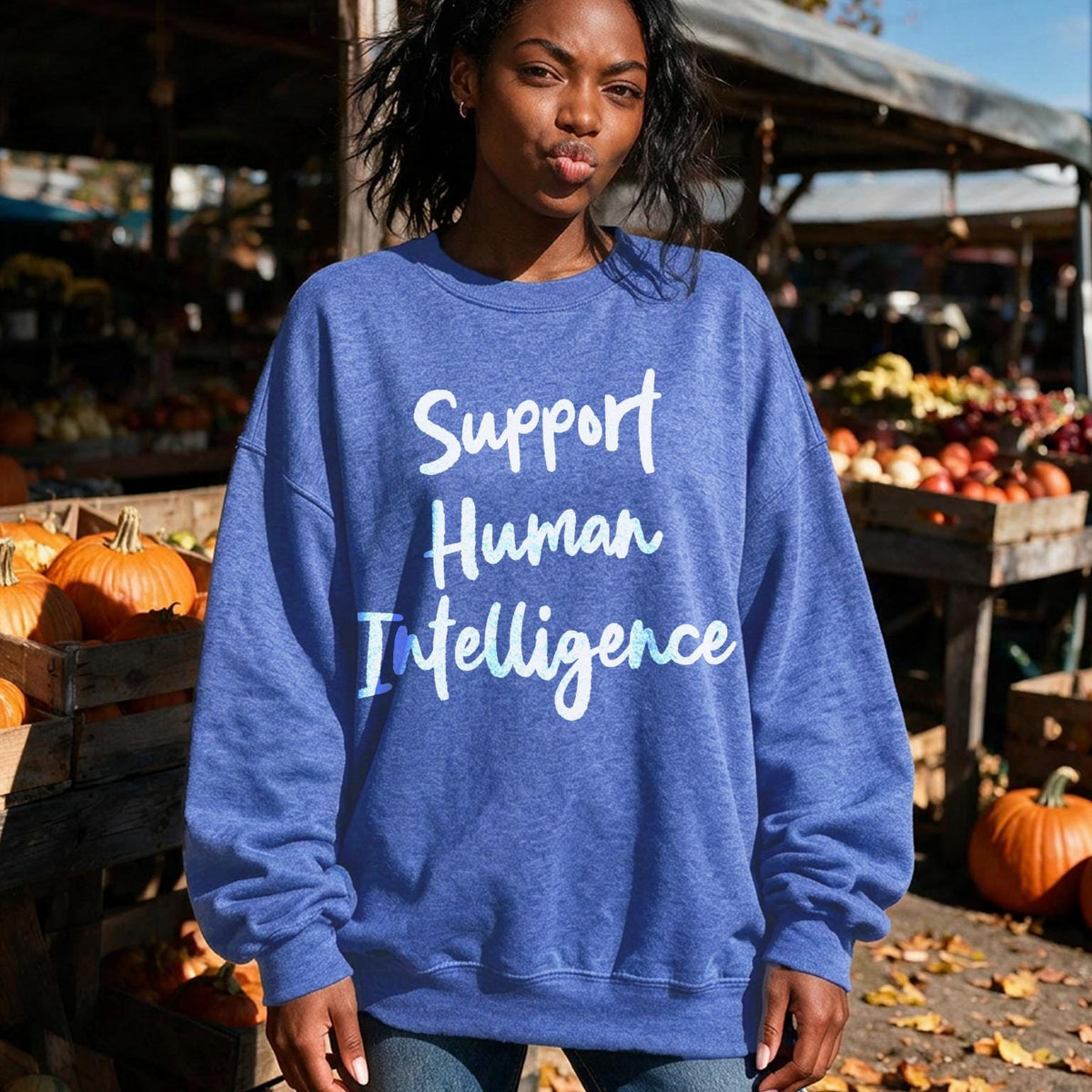 Blue sweatshirt with &amp;quot;Support Human Intelligence&amp;quot; text on a woman in an outdoor market.