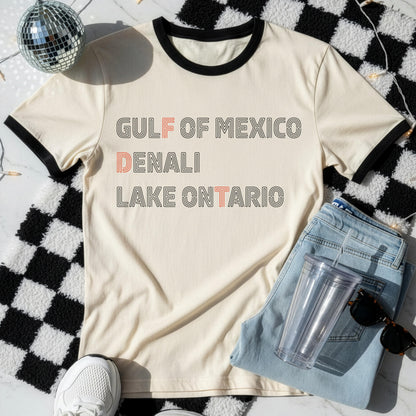 Cream ringer t-shirt with &amp;quot;Gulf of Mexico,&amp;quot; &amp;quot;Denali,&amp;quot; and &amp;quot;Lake Ontario&amp;quot; text.