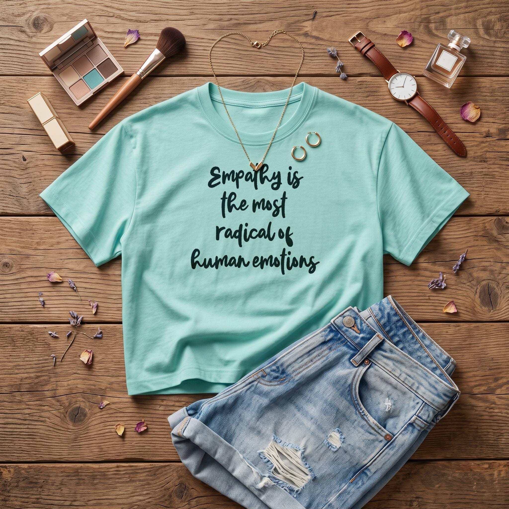 Teal t-shirt with &amp;quot;Empathy is the most radical of human emotions&amp;quot; text, denim shorts, and accessories.