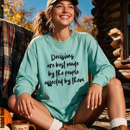 Woman wearing mint sweatshirt with black text &amp;quot;Decisions are best made by the people affected by them.&amp;quot;