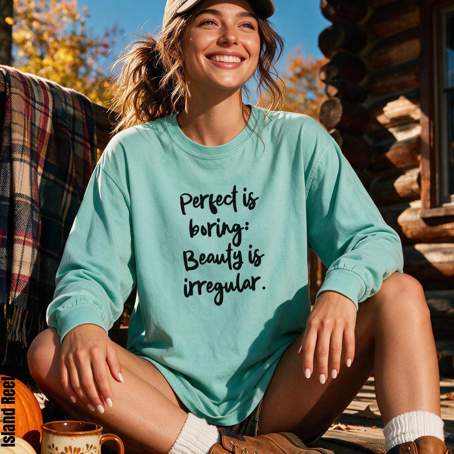 Woman wearing teal long-sleeve shirt with text &amp;quot;Perfect is boring: Beauty is irregular.&amp;quot;