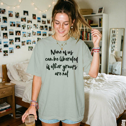 Light green t-shirt with text: &amp;quot;None of us can be liberated if other groups are not&amp;quot;.