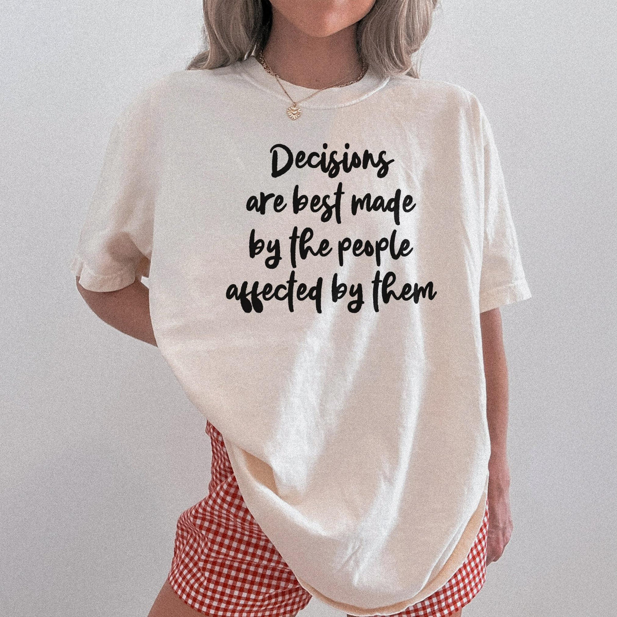Cream t-shirt with black text &amp;quot;Decisions are best made by the people affected by them.&amp;quot;