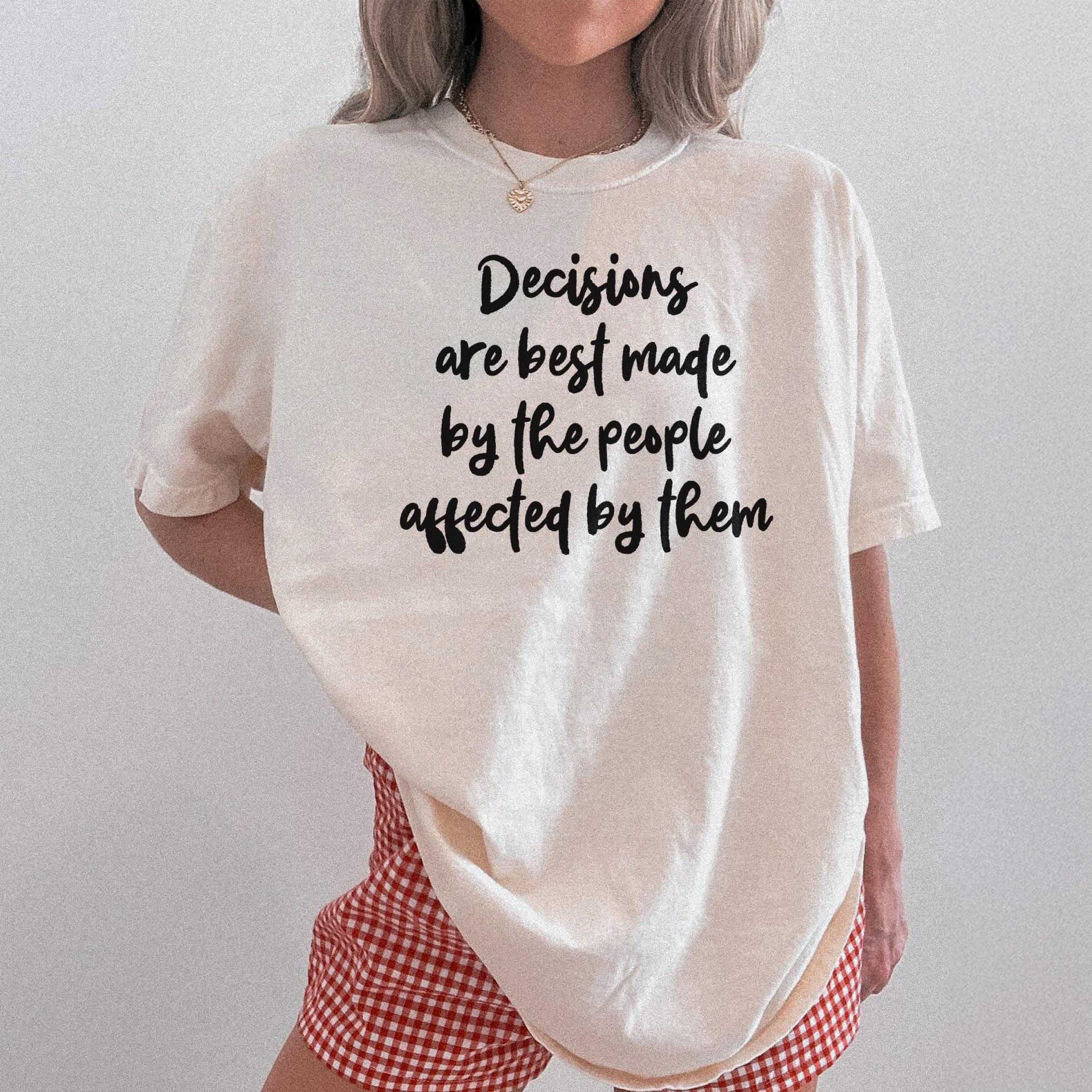 Cream t-shirt with black text &amp;quot;Decisions are best made by the people affected by them.&amp;quot;