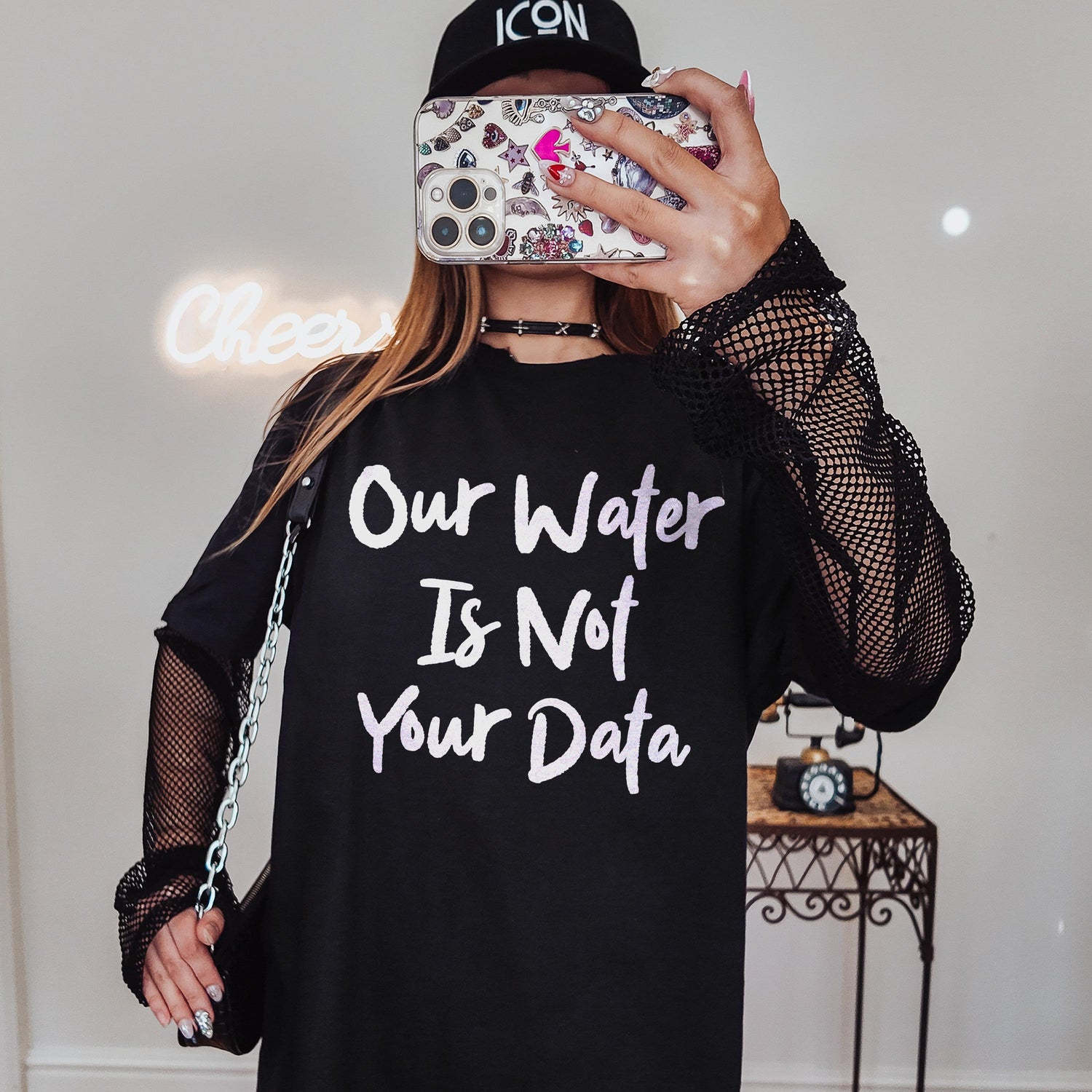 Black long-sleeve shirt with &amp;quot;Our Water Is Not Your Data&amp;quot; text and fishnet sleeves.