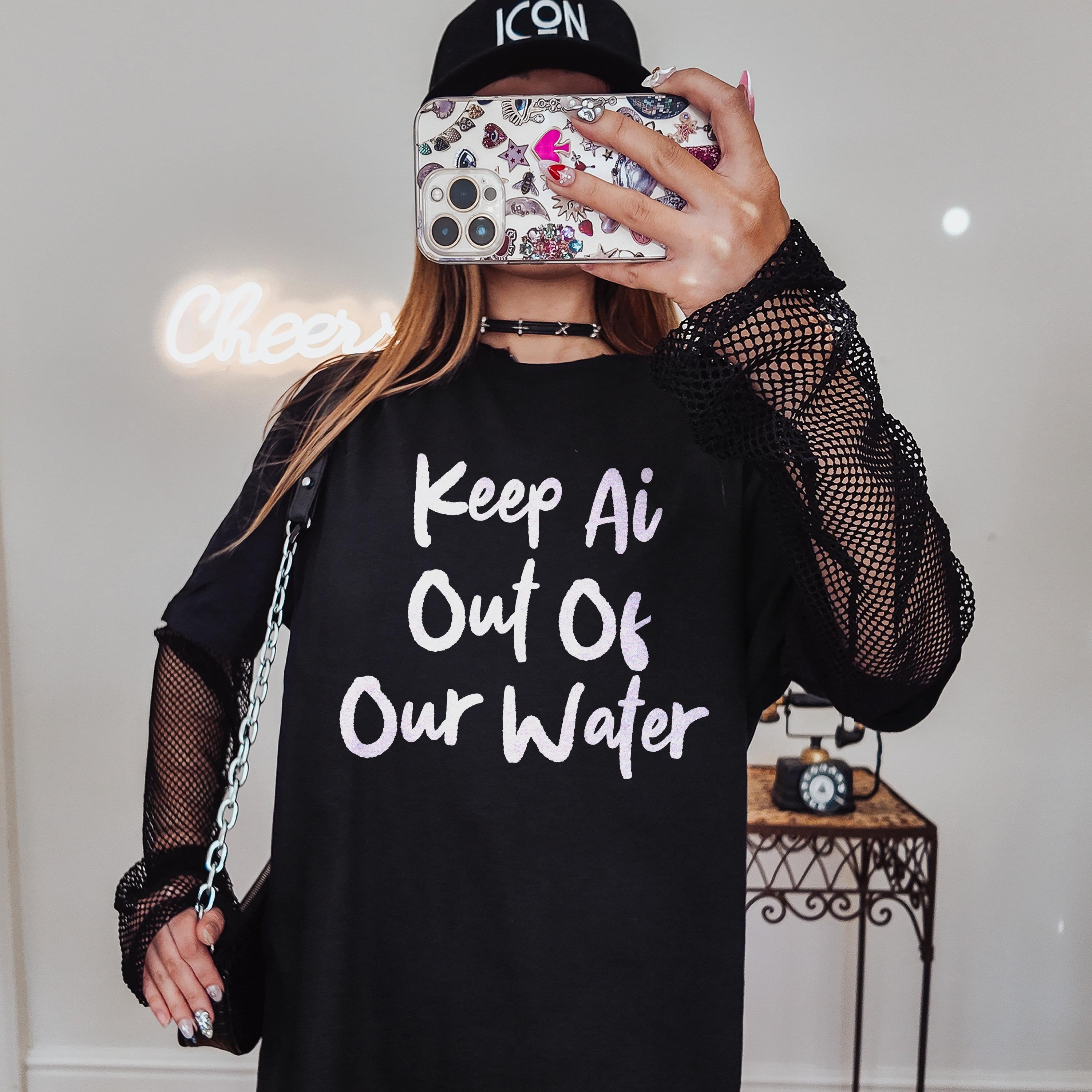 Woman wearing black t-shirt with &amp;quot;Keep Ai Out Of Our Water&amp;quot; text and fishnet sleeves.