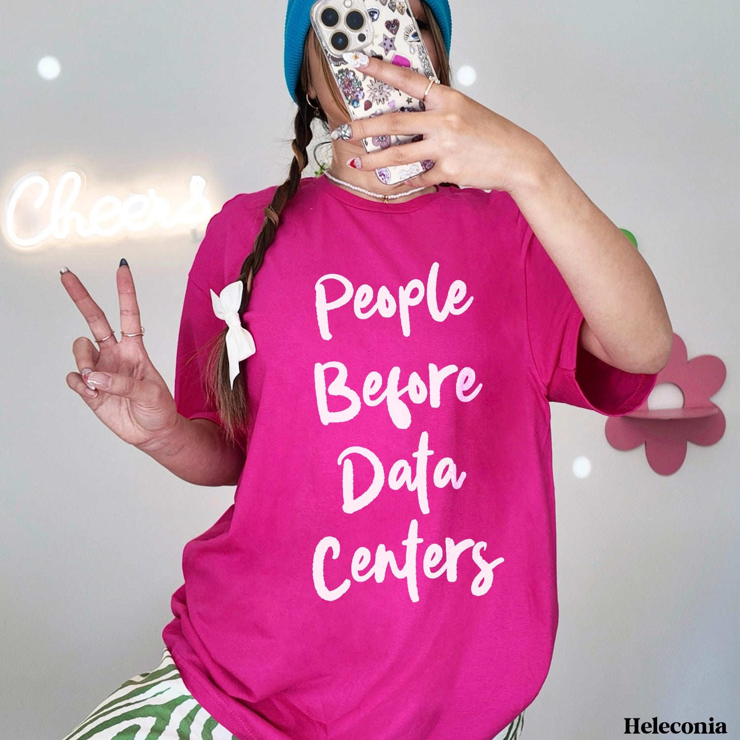Woman in pink t-shirt with &amp;quot;People Before Data Centers&amp;quot; text, holding a phone.