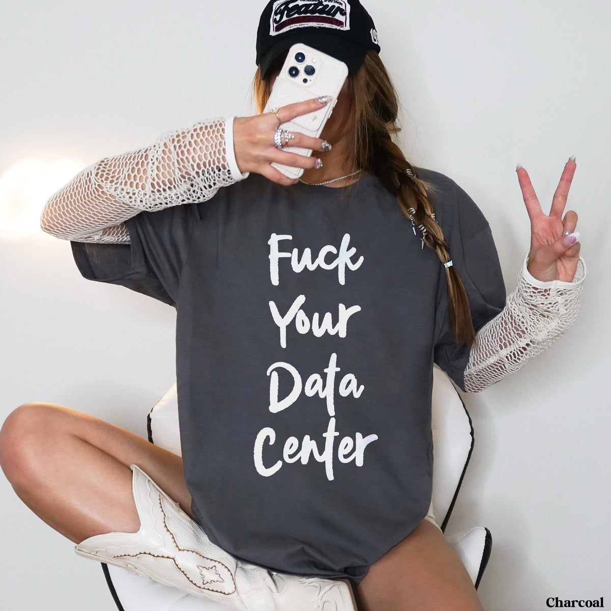 Woman in dark grey t-shirt with white text &amp;quot;Fuck Your Data Center,&amp;quot; white cowboy boots.